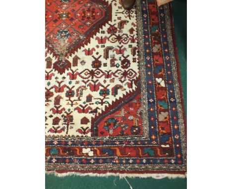 An Indian carpet circa 1930, the cream field centred by a serrated hexagon framed by triple borders. 290cm x 190cm