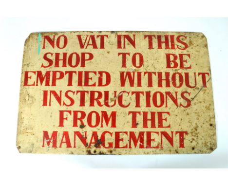 An Edwardian hand painted enamel shop sign, the cream coloured ground with red painted lettering reading ‘No vat in this shop