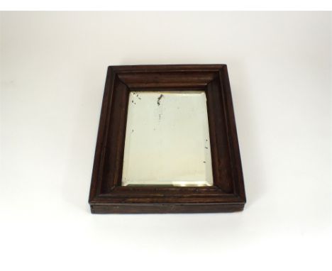 A decorative 19th century or earlier oak framed pine backed wall mirror of portrait/rectangular form enclosing an early, fati