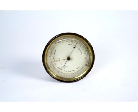 An Edwardian circular brass cased Aneroid barometer, the silvered dial with black stamped numerals and the mercury barometer,