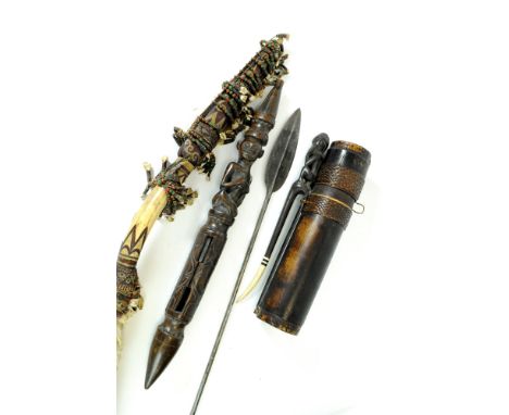 An African carved wooden arrow quiver, together with a carved shaker stick, a small spear and three component parts of a Masa