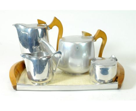 An associated five-piece Picquot ware tea set comprising tray, tea pot and hot water jug, each with polished hardwood handles