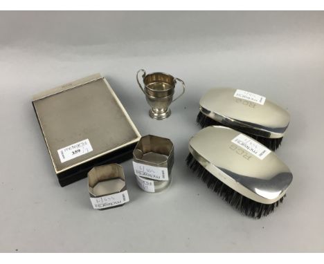 NOTE PAD WITH ENGINE TURNED SILVER COVER, along with two silver backed hair brushes, three silver napkin rings and a small pr