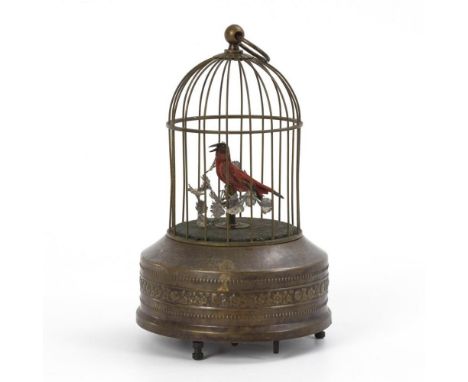 SingvogelautomatUm 1900.             Messing, gefärbte Federn und Stoff. H 24 cm.             Runder Käfig mit floralem Relie