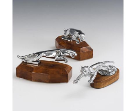 3 Jaguar-"Kühlerfiguren"Je ungemarkt.             Helles Metall, wohl verchromt. Holzsockel, 2x mit Maserfurnier. L je 19 cm.