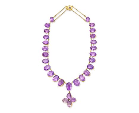 AMETHYST NECKLACE, CIRCA 1900The graduated series of oval-cut amethysts suspending a similarly-set pendant of quatrefoil desi