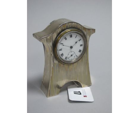 A Hallmarked Silver Mounted Bedside Clock, JGLtd, Birmingham 1916, of shaped design with engine turned decoration, 9.8cm high