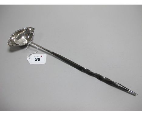A Toddy Ladle, the oval bowl with twin spouts and inset 1787 George III shilling, with twisted handle, overall length approxi