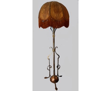 An  Arts &amp; crafts wrought iron and brass adjustable standard lamp, on three leaf form feet, with scallop edge tasselled  