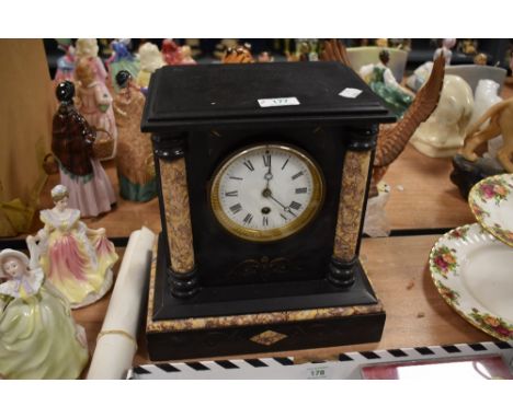 A Victorian French mantel clock having marble column inserts and enamel dial