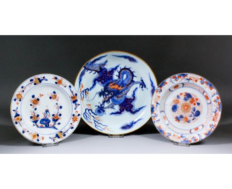 A Chinese blue and white porcelain saucer dish painted with a dragon chasing the sacred pearl amongst clouds, overpainted in 