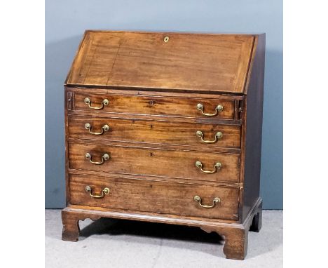 A George III mahogany bureau, the slope enclosing eight arched top pigeon holes, eight small drawers and central cupboard enc