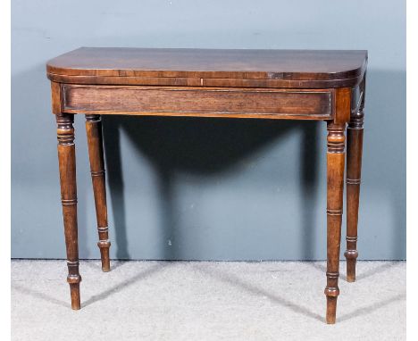 A late George III mahogany D-shaped card table with baize lined folding top, bead ornament to panelled apron, on turned legs,