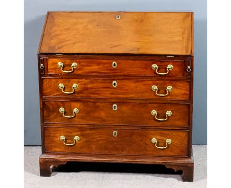 A George III mahogany bureau, the slope enclosing pigeon holes, central cupboard flanked by drawers with split turned fluted 