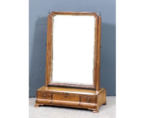 An 18th Century walnut toilet mirror with gilt inner slip, on tapered uprights with turned finials, the base fitted three sma