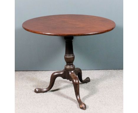 A George III mahogany circular tripod occasional table, the solid top on turned central column, on cabriole legs with pad fee