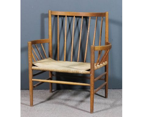 An early 20th Century oak and beechwood stick back armchair of "Arts & Craft" design, with curved crest rail and bold arm sup