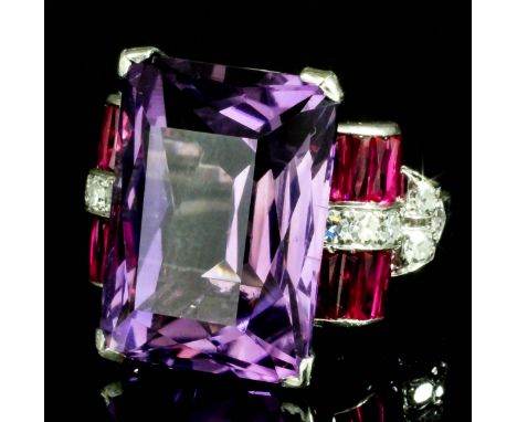 A 1920's silvery coloured metal mounted amethyst, ruby, and diamond set ring, the rectangular cushion cut amethyst of approxi