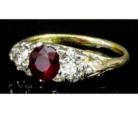 A modern 18ct gold mounted ruby and diamond ring, the circular cut ruby of .80ct, shouldered by two brilliant cut diamonds, e