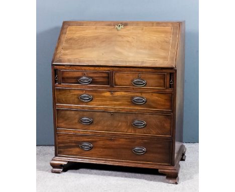 An Edwardian mahogany bureau of "Georgian" design, the crossbanded slope inlaid with chequered stringing, enclosing central c