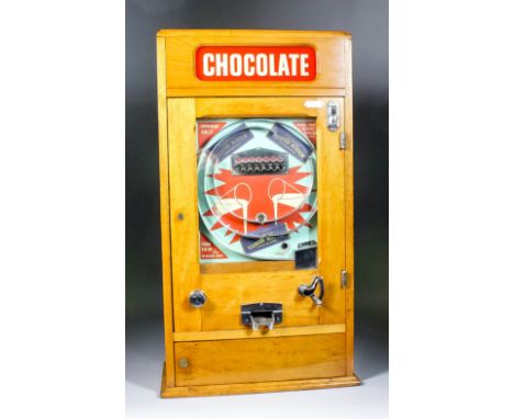 A 1950s oak cased "Penny-in-the-slot"  "Win a Chocolate Bar" Alwin flicker machine by Ruffle & Walker, the front advertising 