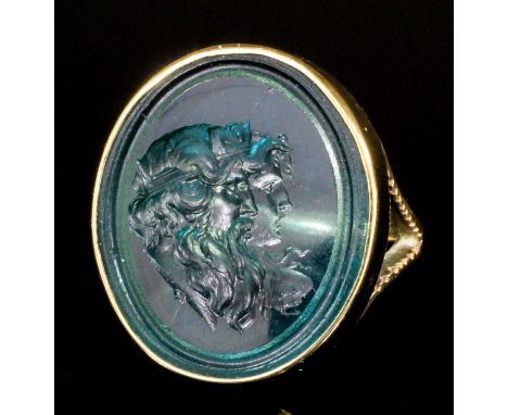 A gentleman's gold coloured metal mounted glass intaglio set ring, the oval glass stone carved with a profile of a classical 