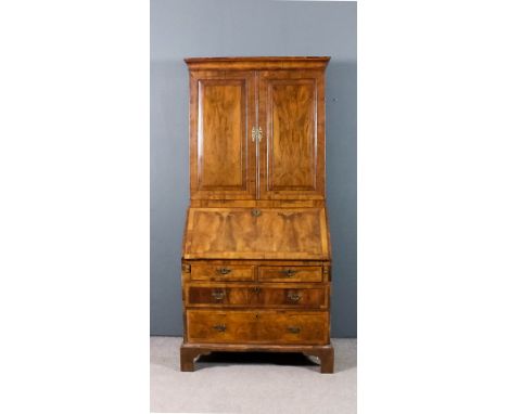 A George II walnut bureau cabinet inlaid with herringbone bandings and crossbanded, the upper part with moulded cornice, fitt