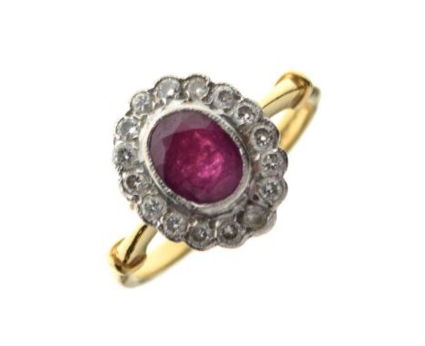 18ct gold, ruby and diamond cluster ring, size N, 4.7g gross approxCondition report: The oval ruby appears cloudy and opaque,