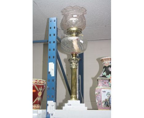 A BRASS OIL LAMP, with glass shade, funnel and well on stepped marble base