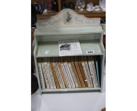 A PETER RABBIT'S BOOK SHELF, painted pale green, containing eighteen Beatrix Potter books, guide to Hill Top, etc