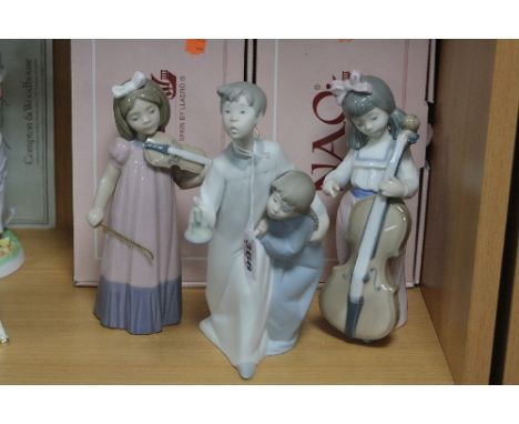 A LLADRO FIGURE GROUP, boy and girl with candle, together with two boxed Nao young girl musicians, 'Violin' and 'Cello' (miss