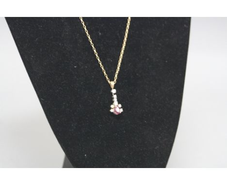 A MODERN 9CT GOLD RUBY AND DIAMOND PENDANT, one pear shape ruby measuring approximately 6.88mm x 5mm, eight modern brilliant 