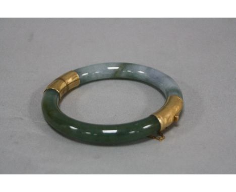 A MODERN JADE BANGLE, round in shape, hinged, measuring approximately 75mm in diameter, jade measuring approximately 8.8mm in