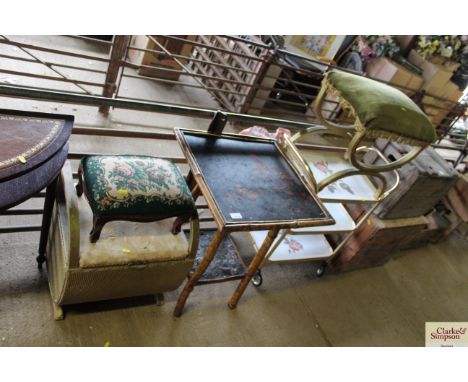A gold loom style laundry stool with internal storage; a green and gold tasselled footstool; a green floral decorated footsto