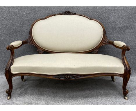 A Victorian carved walnut frame sofa reupholstered in piped calico. H.98 W.139 D.72cm