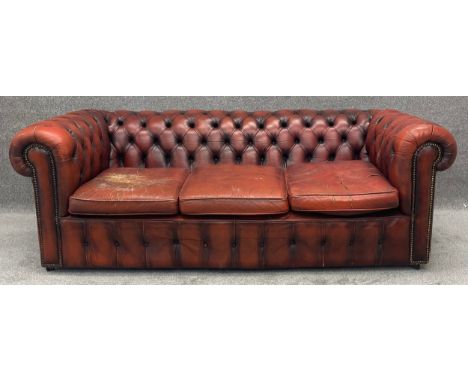 A three seater Chesterfield sofa in leather upholstery. H.69 W.204 D.100cm (Wear and tear as seen).
