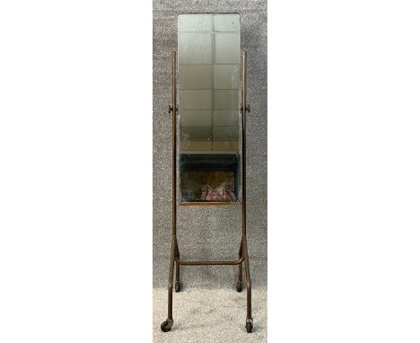 A mid century industrial style cheval mirror with a bevel plate in an adjustable metal frame on castors. H.147cm