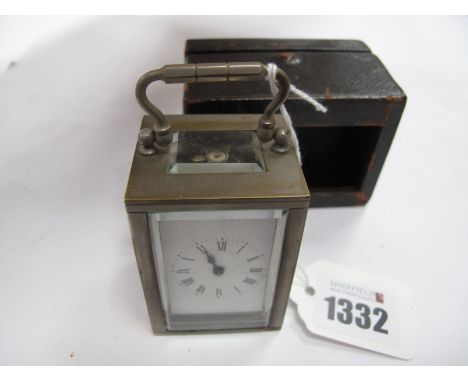 A French Made Travelling Clock, circa 1900 in plated casing 4.5cm high, and Morocco holder.