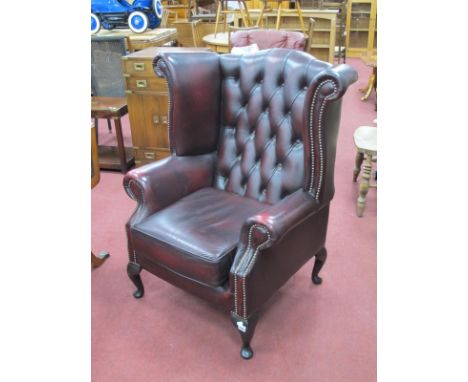 Claret Leather Wing Armchair, with button back and studded decoration, on cabriole legs. 