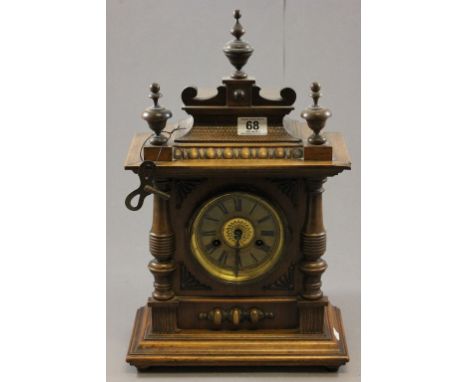 A 20th century oak cased mantel clock, with turned finials on bun feet, with German movement