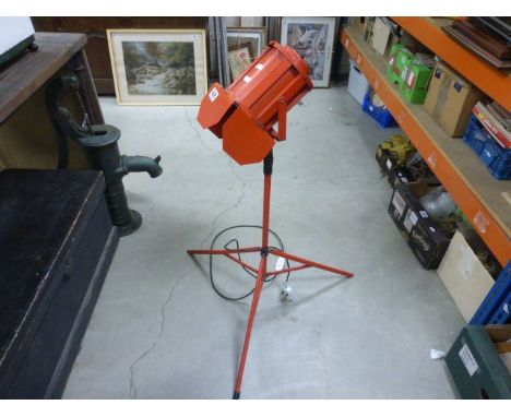A vintage red spotlight lamp, on tripod base