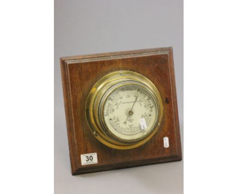 Vintage brass cased barometer on oak backing, Norie & Wilson London         