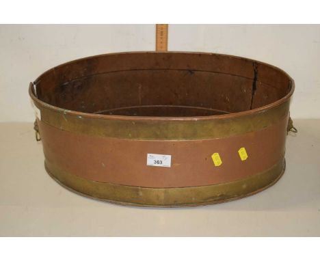 An oval copper and brass planter