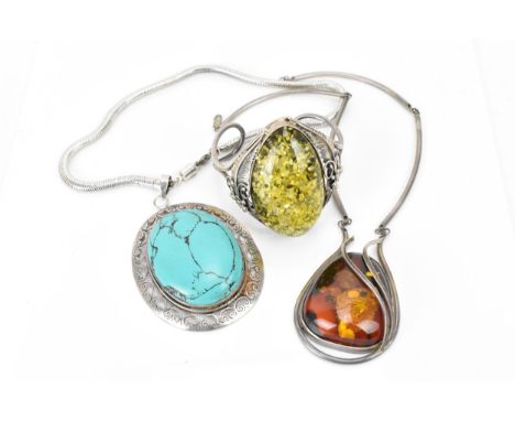 A Native American white metal and green amber bangle, with central large oval polished amber cabochon in a naturalistic leaf 