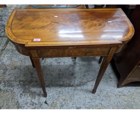 A Georgian breakfront card table, crossbanded in satinwood, strung in boxwood and ebony on squared tapering legs with spade f