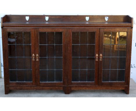 Liberty &amp; Co oak bookcase, with pierced heart back rail and leaded glass doors, ivorine label Liberty &amp; Co Regent Str