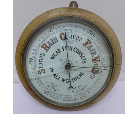 A circular aneroid barometer, with advertising dial, 'Wear Fitu Corsets In All Weathers', glass a/f