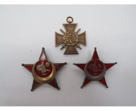 Two Turkish Gallipoli Starsconsisting brass and enamel example (damage to one arm).  Rear brooch fitting and crudely engraved