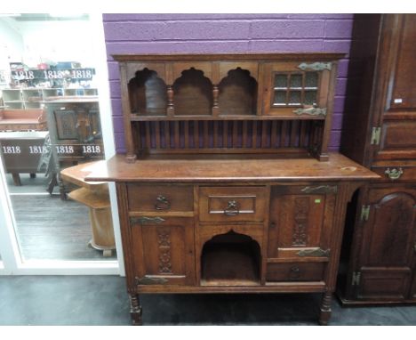 A late Victorian oak sideboard in the Arts & Crafts style having raised gallery back over central drawer and recess flanked b