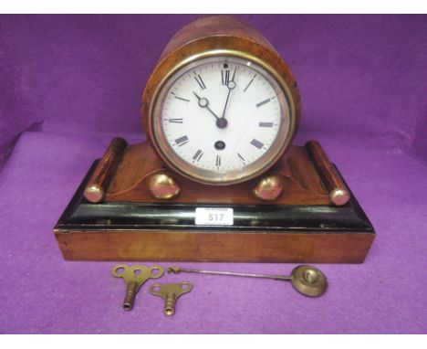 A late 19th century stained wood mantel clock of cylindrical and scroll design, with Roman numeral dial